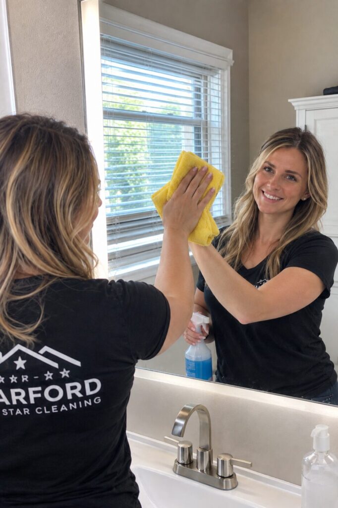 Harford 5 Star Cleaning technician cleaning a bathroom mirror