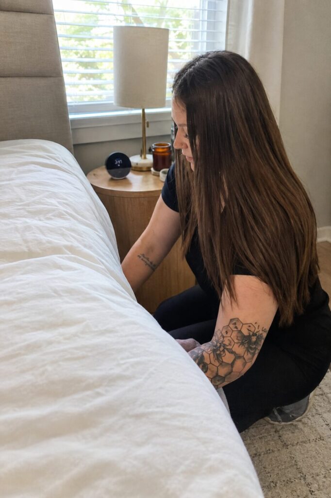 Harford 5 Star Cleaning technician making a bed in a bright bedroom