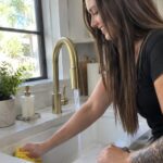 Harford 5 Star Cleaning technician cleaning a kitchen sink and faucet