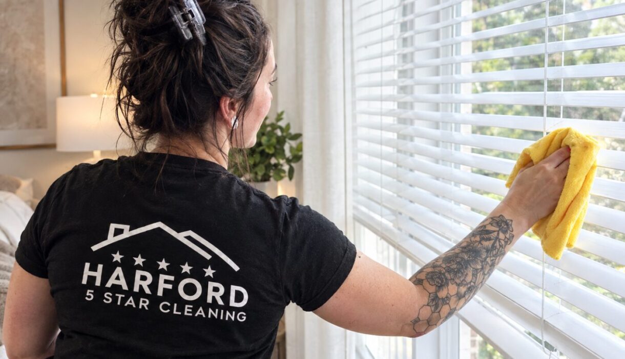 Harford 5 Star Cleaning technician wiping bedroom blinds