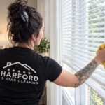 Harford 5 Star Cleaning technician wiping bedroom blinds